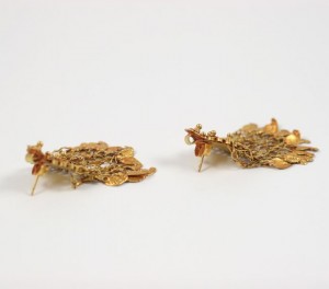 A pair of gold earrings with leaves on them.