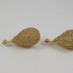 A pair of gold earrings with star shaped tops.