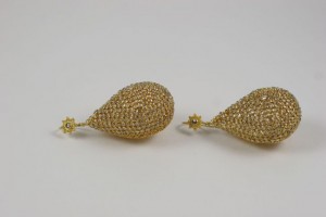 A pair of gold earrings with star shaped tops.