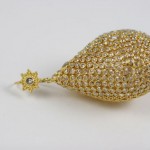 A gold and diamond pear shaped earring.