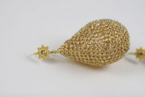 A gold and diamond pear shaped earring.