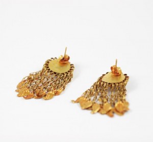 A pair of gold earrings with dangling chains.
