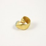 A gold ring with a small white stone on top of it.