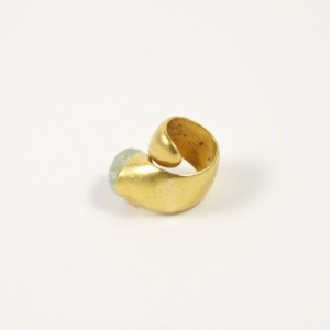 A gold ring with a small white stone on top of it.