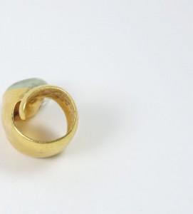 A gold ring with a blue stone on top of it.
