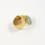 A gold ring with a green stone on it