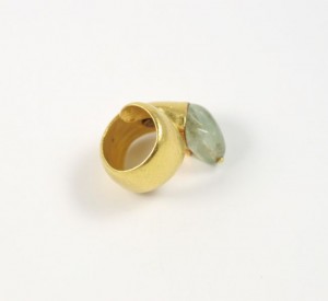 A gold ring with a green stone on it