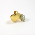 A gold ring with a green stone on it.