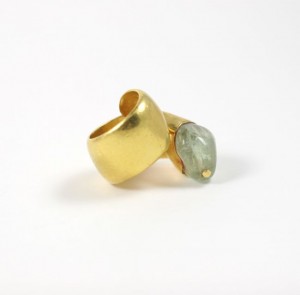A gold ring with a green stone on it.