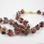 A necklace of purple flowers with gold accents.