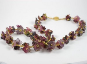 A necklace of purple flowers with gold accents.