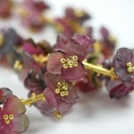 A close up of some purple flowers with gold stems