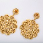 A pair of gold earrings with intricate design.