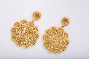 A pair of gold earrings with intricate design.