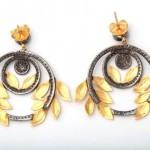 A pair of earrings with yellow stones and black diamonds.