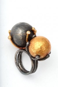 A black and gold ring with two balls on it