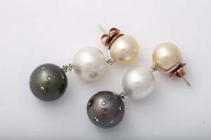 A pair of earrings with pearls and diamonds.
