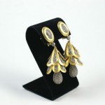 A pair of earrings on display in a black holder.