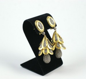 A pair of earrings on display in a black holder.