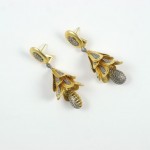 A pair of earrings with gold and silver flowers.