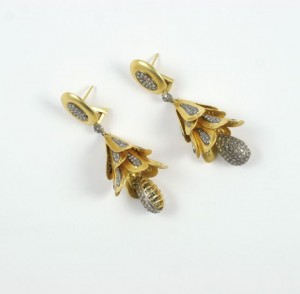 A pair of earrings with gold and silver flowers.