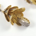 A close up of the gold and diamond flower earrings.