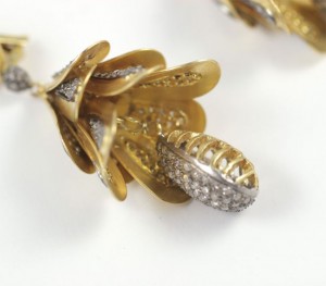 A close up of the gold and diamond flower earrings.