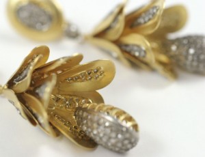 A close up of the gold and diamond earrings.