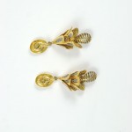 A pair of gold earrings with leaves and swirls.