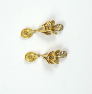 A pair of gold earrings with leaves and swirls.