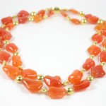 A necklace of orange and gold beads is shown.