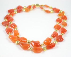 A necklace of orange and gold beads is shown.