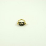 A gold ring with a black stone on it