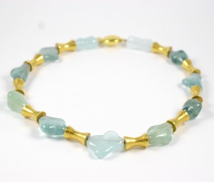 A necklace of green and blue beads with gold accents.