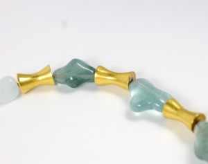 A close up of three beads on a white surface
