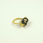 A gold ring with black and white stones on it.