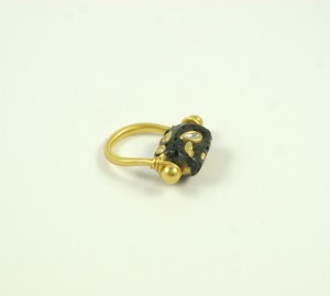 A gold ring with black and white stones on it.