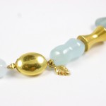 A close up of the gold bead and blue beads.