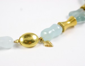 A close up of the gold bead and blue beads.