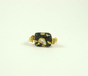A black and gold bead ring with a pearl in the middle.