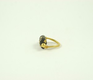 A gold ring with black stones on it