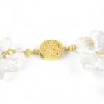 A close up of the gold bead on the necklace