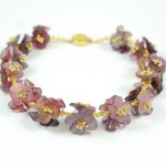 A purple flower bracelet with gold beads