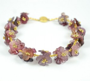 A purple flower bracelet with gold beads