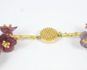 A close up of the gold bead on the necklace