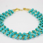 A necklace with turquoise flowers and gold chain.