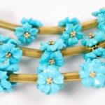 A close up of some blue flowers on a gold chain