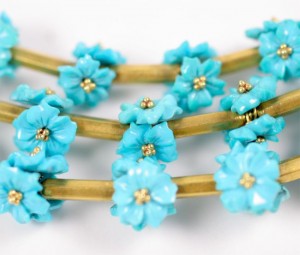 A close up of some blue flowers on a gold chain