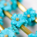 A close up of some blue flowers on a gold chain