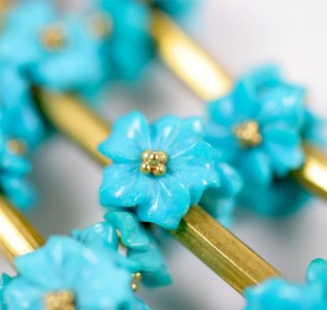 A close up of some blue flowers on a gold chain